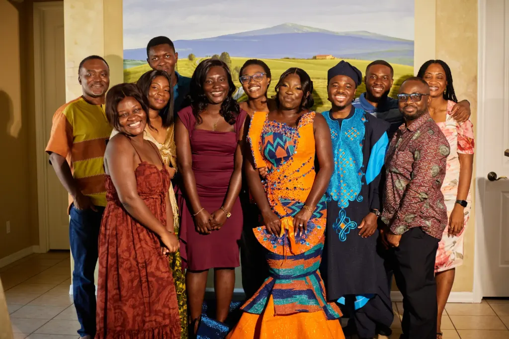Family and friends gathered around the couple in their kente and blue robes