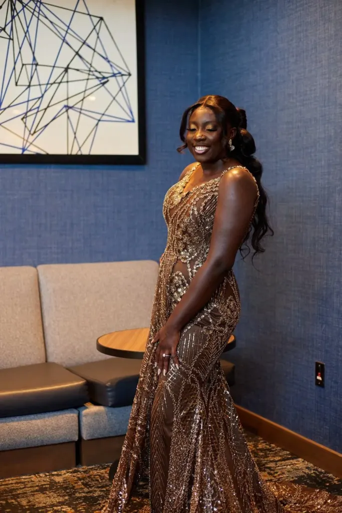 Bride against a blue wall in a gold beaded gown
