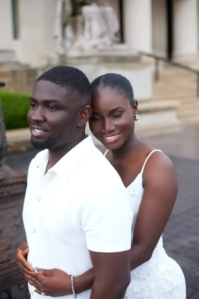 Bride embracing groom from behind, eyes closed, smiling